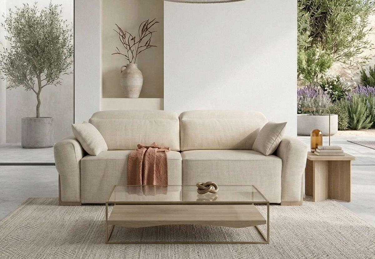 Sofá Emma de A.V. Sofás en beige con cojines y manta, en salón luminoso